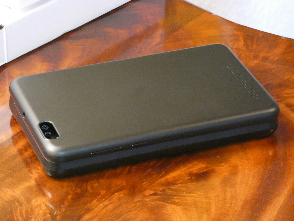 A photo of the empty closed keyboard case in a three-quarter perspective with the camera hole corner in the front. The power and volume buttons can be seen. It looks like a Nintendo DS XL.